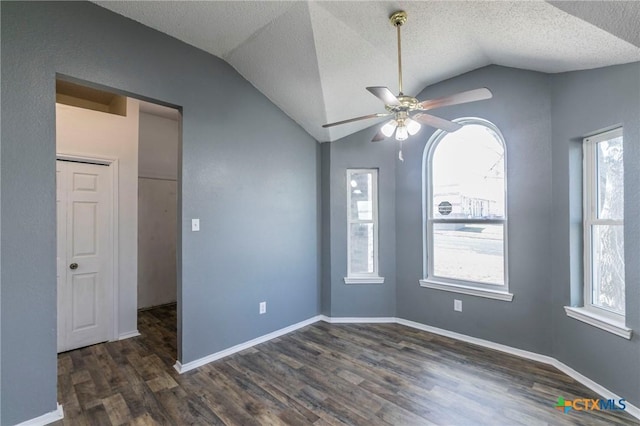 empty room with lofted ceiling, a textured ceiling, dark hardwood / wood-style floors, and ceiling fan