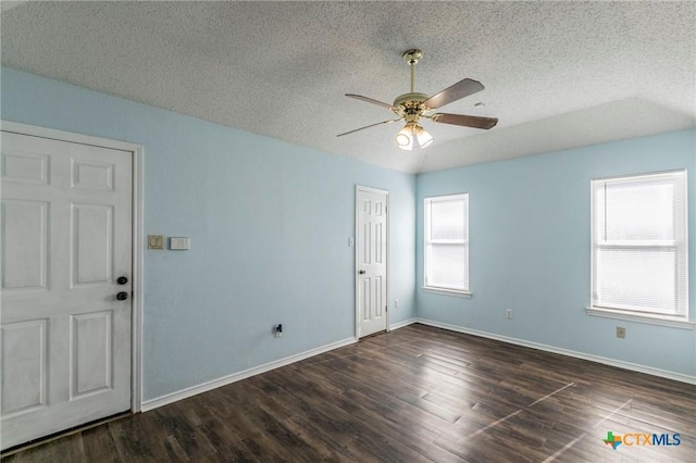 unfurnished room featuring a textured ceiling, dark wood-type flooring, and ceiling fan