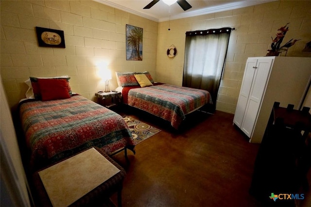 bedroom featuring ceiling fan, concrete block wall, and ornamental molding