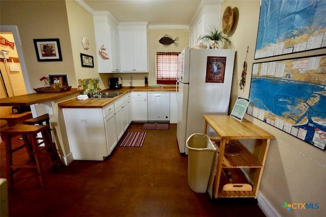 kitchen with white cabinetry, white appliances, a peninsula, and butcher block countertops