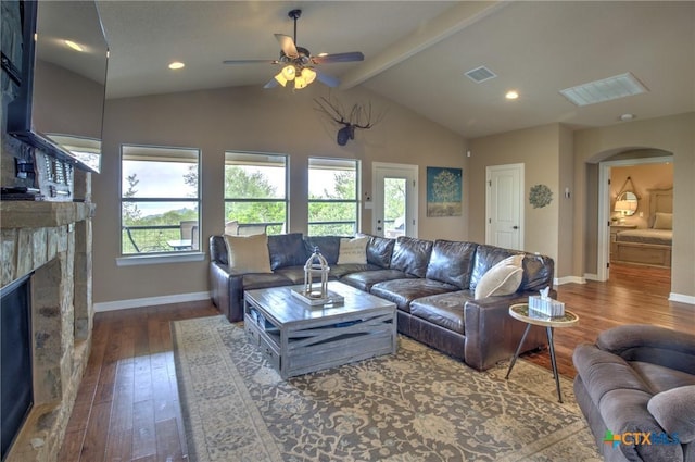 living area featuring a fireplace, arched walkways, a ceiling fan, visible vents, and hardwood / wood-style flooring