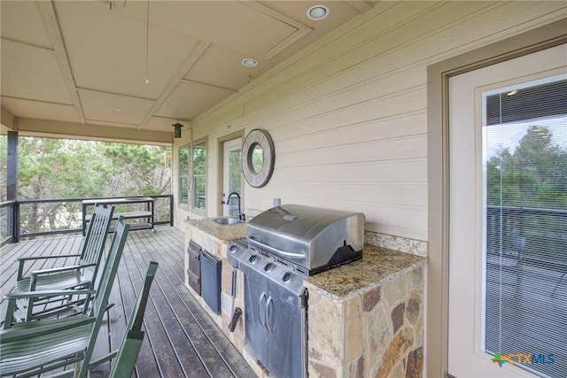 wooden terrace featuring a sink and area for grilling