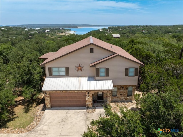 1350 Colleen Dr, Canyon Lake, TX 78133 - view of front of home with stone siding, driveway, an attached garage, a water view, and a forest view