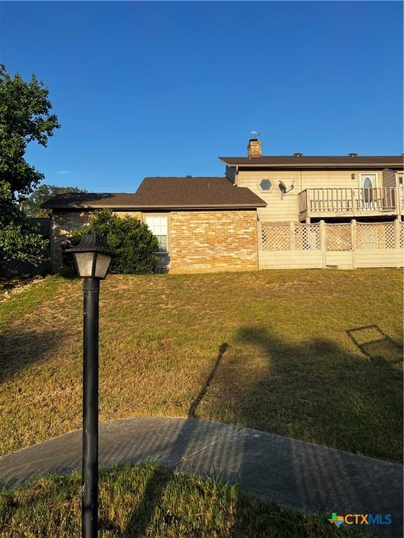 view of side of property featuring a yard and a chimney