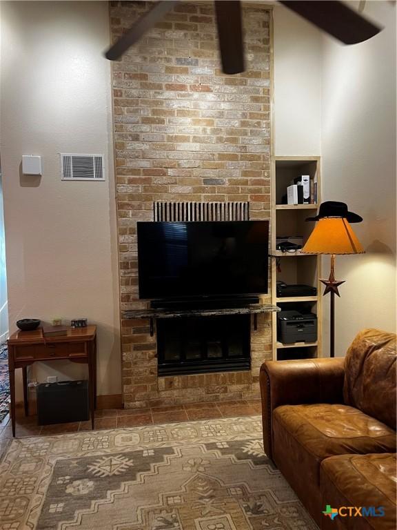 tiled living area featuring a fireplace and visible vents