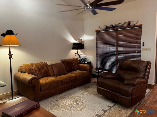 living room with baseboards and ceiling fan