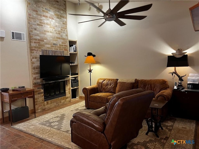 living room with vaulted ceiling, visible vents, a fireplace, and ceiling fan