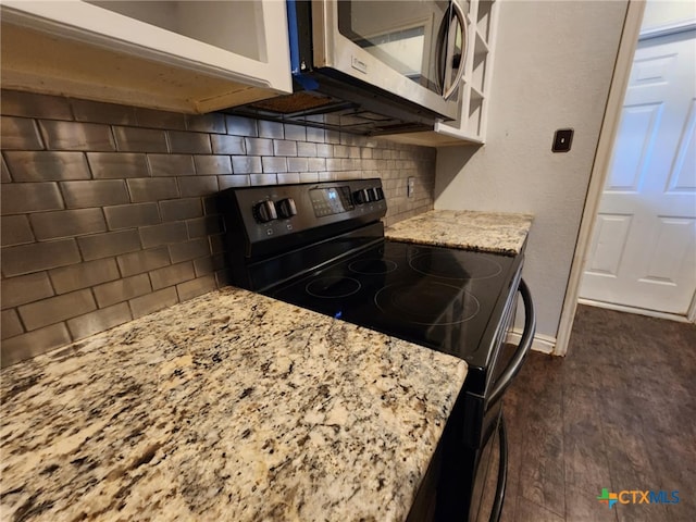 2006 Indian Camp Trl, Copperas Cove, TX 76522 - kitchen featuring black electric range oven, stainless steel microwave, tasteful backsplash, light stone countertops, and dark wood finished floors