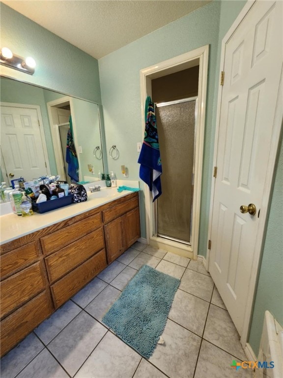 2006 Indian Camp Trl, Copperas Cove, TX 76522 - bathroom with vanity, a stall shower, a textured ceiling, tile patterned floors, and a closet