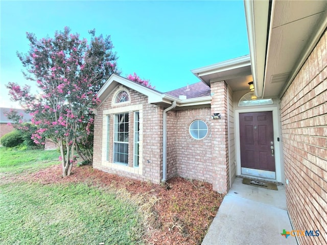 2006 Indian Camp Trl, Copperas Cove, TX 76522 - view of exterior entry featuring brick siding, a lawn, and roof with shingles