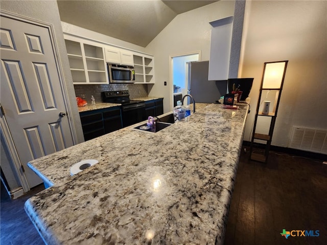 2006 Indian Camp Trl, Copperas Cove, TX 76522 - kitchen featuring appliances with stainless steel finishes, open shelves, lofted ceiling, light stone counters, and white cabinets