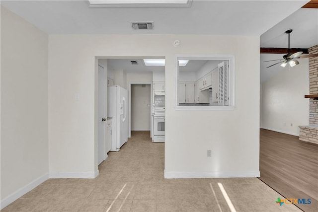 interior space with ceiling fan and a stone fireplace