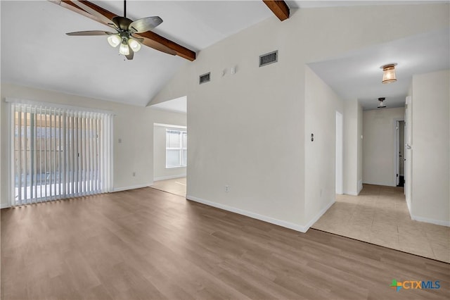 spare room featuring ceiling fan, light hardwood / wood-style flooring, and vaulted ceiling with beams