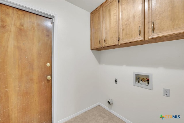 clothes washing area featuring electric dryer hookup, cabinets, and washer hookup