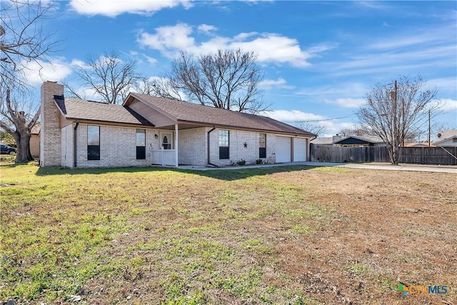 rear view of house with a garage and a yard