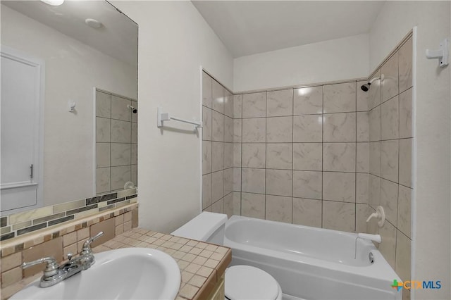 full bathroom with tiled shower / bath combo, toilet, decorative backsplash, and vanity