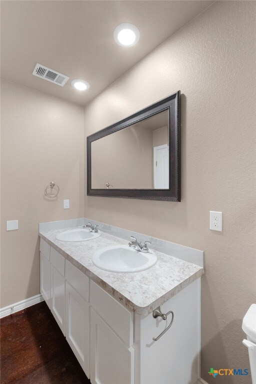 bathroom featuring wood-type flooring, vanity, and toilet