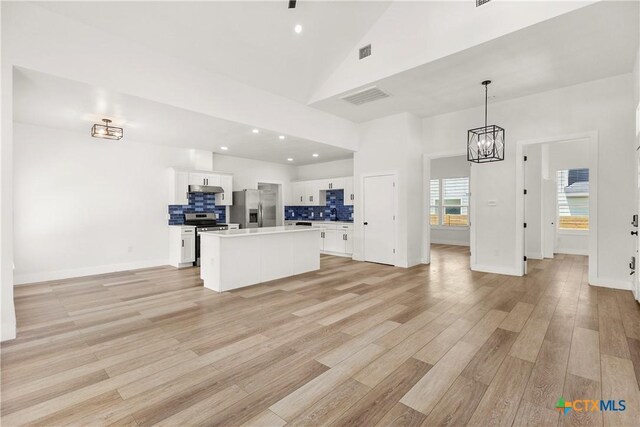 324 Idaho St, San Antonio, TX 78203 - unfurnished living room with a chandelier, light wood-style floors, high vaulted ceiling, recessed lighting, and baseboards