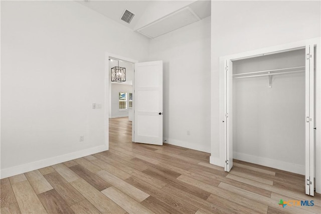 324 Idaho St, San Antonio, TX 78203 - unfurnished bedroom with wood finished floors, baseboards, a chandelier, and a closet