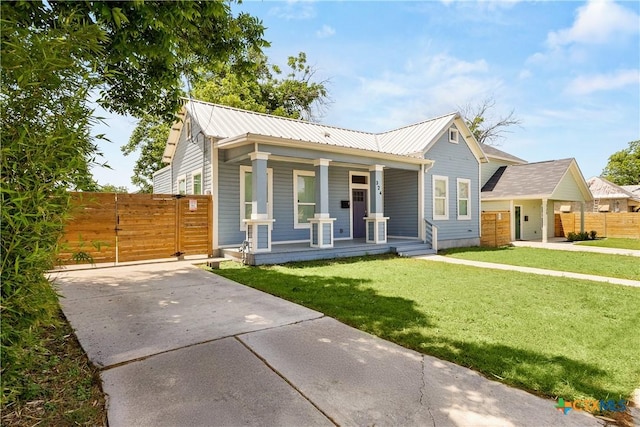 324 Idaho St, San Antonio, TX 78203 - view of front of house featuring covered porch, driveway, metal roof, and a gate