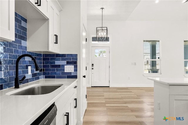 324 Idaho St, San Antonio, TX 78203 - kitchen with a sink, light wood-style flooring, white cabinets, a chandelier, and light countertops