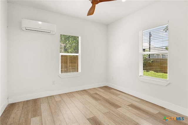 324 Idaho St, San Antonio, TX 78203 - empty room featuring an AC wall unit, light wood-style flooring, baseboards, and a ceiling fan