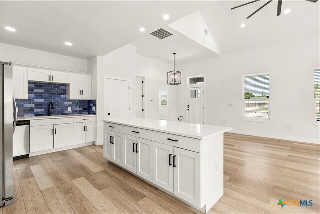 324 Idaho St, San Antonio, TX 78203 - kitchen with light wood finished floors, white cabinetry, tasteful backsplash, light countertops, and dishwasher