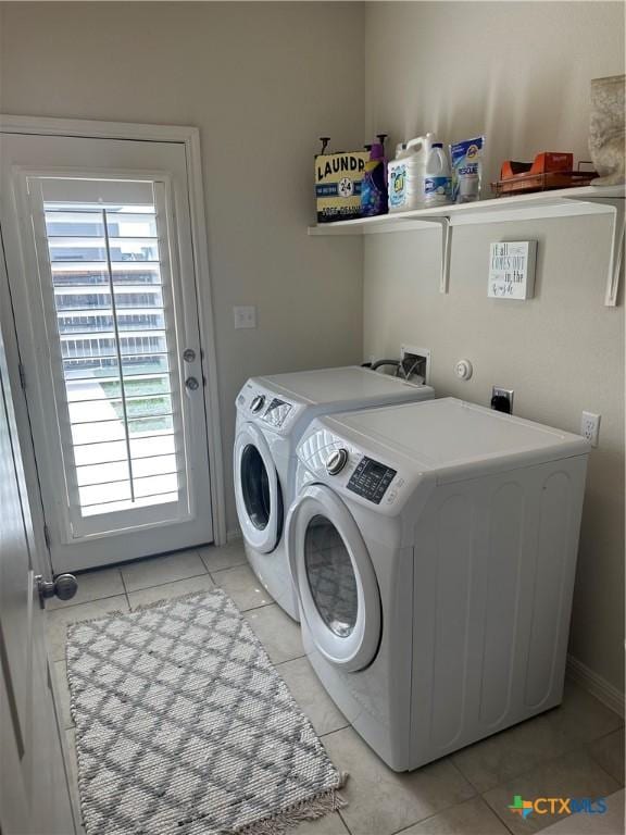 1157 Esplanade Pkwy, San Marcos, TX 78666 - laundry area featuring washing machine and clothes dryer and light tile patterned floors