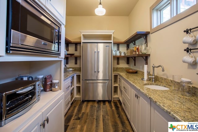 164 Cypress Way, Mcqueeney, TX 78123 - kitchen featuring stainless steel appliances, open shelves, dark wood finished floors, light stone countertops, and white cabinets