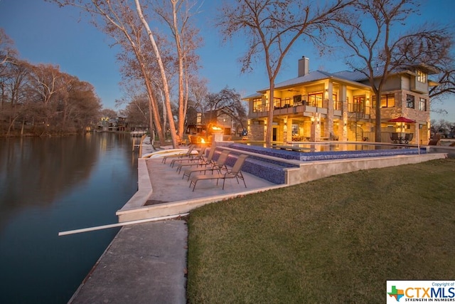 exterior space featuring a balcony, a water view, and a patio area