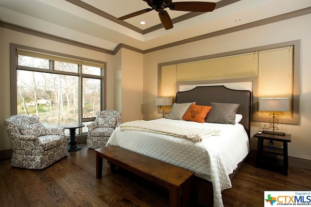 bedroom with dark hardwood / wood-style flooring, ornamental molding, a tray ceiling, and ceiling fan