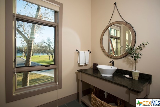 bathroom featuring vanity, tile patterned floors, and a water view