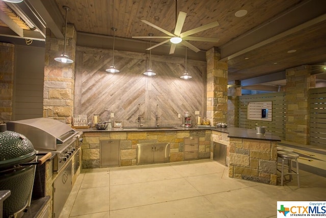 exterior space with area for grilling, ceiling fan, and exterior kitchen