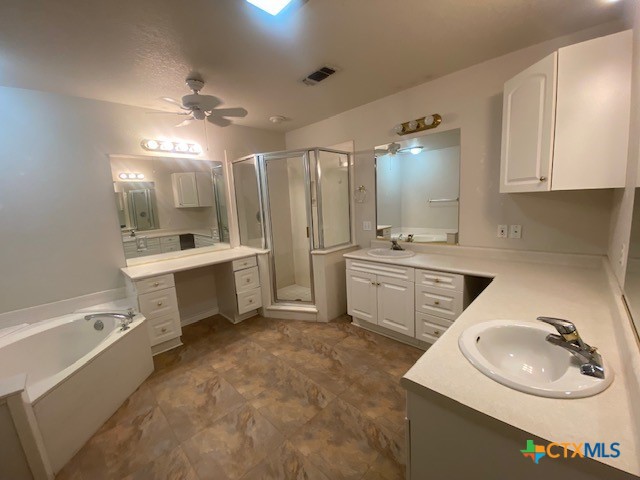 bathroom featuring ceiling fan, vanity, separate shower and tub, and a textured ceiling