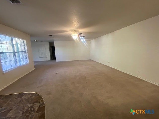 carpeted spare room featuring ceiling fan