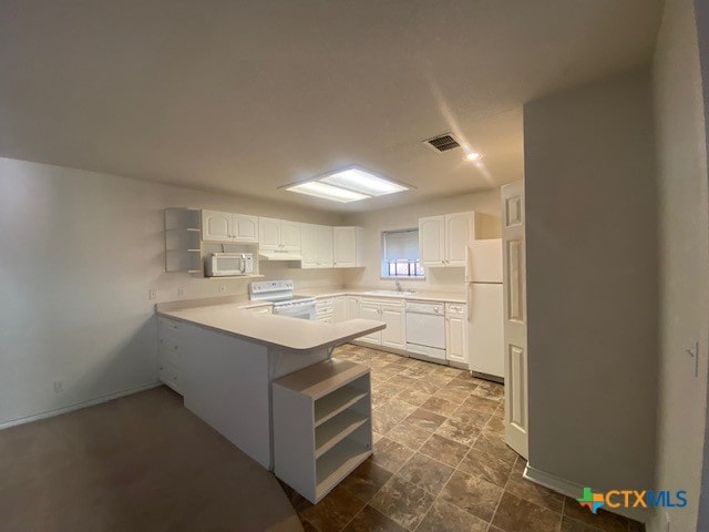 kitchen with sink, white appliances, white cabinets, and kitchen peninsula