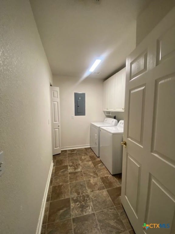 clothes washing area with cabinets, washer and dryer, and electric panel