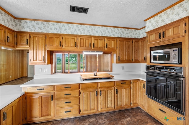 kitchen with cooktop, crown molding, black oven, a textured ceiling, and stainless steel microwave