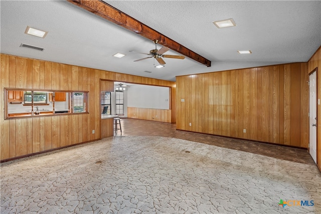 unfurnished living room featuring a textured ceiling, ceiling fan, and plenty of natural light