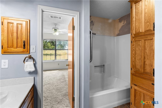 bathroom featuring shower / bath combination, vanity, a textured ceiling, and ceiling fan