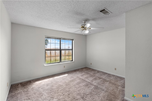 empty room with a textured ceiling, light colored carpet, and ceiling fan