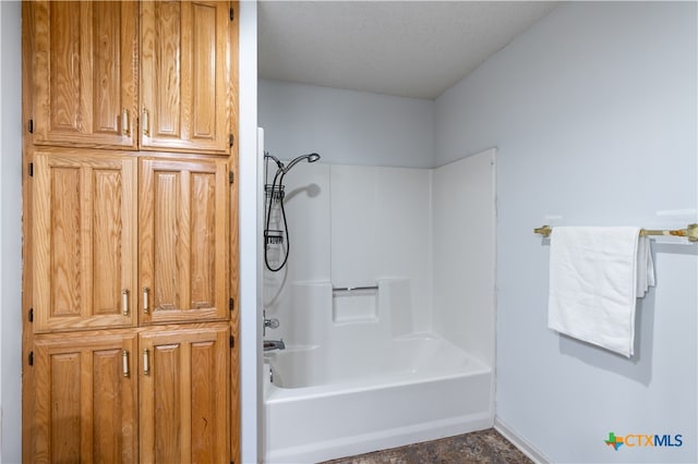 bathroom featuring shower / bathing tub combination and a textured ceiling