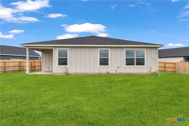 back of property featuring board and batten siding, a yard, and a fenced backyard