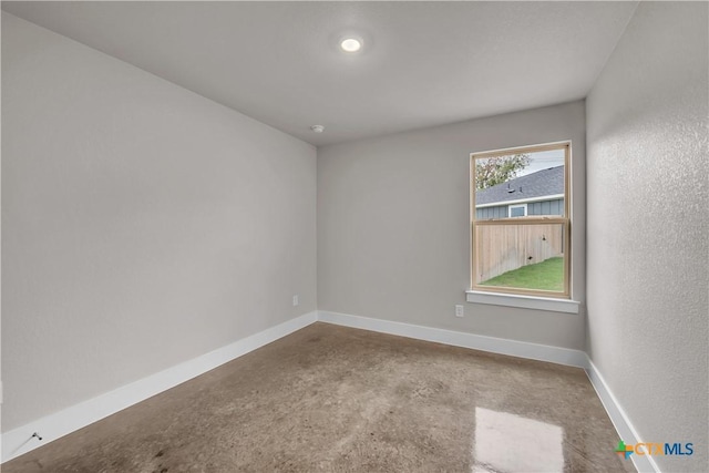 empty room featuring concrete floors and baseboards