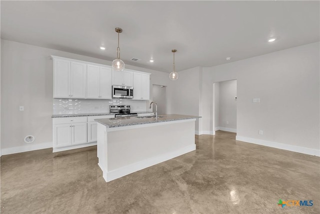 kitchen featuring finished concrete floors, an island with sink, a sink, stainless steel appliances, and baseboards