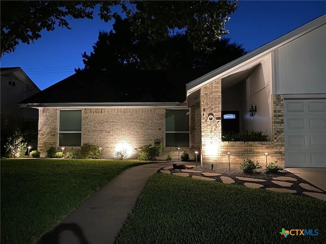 107 Savannah Dr, Victoria, TX 77904 - view of front of home with a yard, brick siding, and a garage