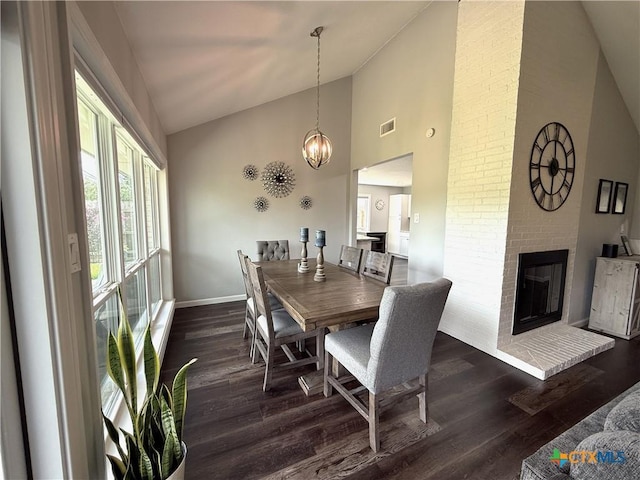 107 Savannah Dr, Victoria, TX 77904 - dining room with dark wood-style floors, high vaulted ceiling, a brick fireplace, and a chandelier