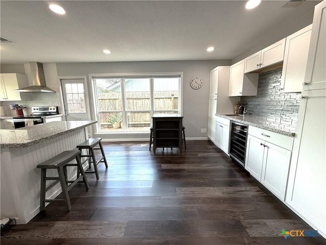 107 Savannah Dr, Victoria, TX 77904 - kitchen with wall chimney exhaust hood, beverage cooler, electric range, light stone counters, and recessed lighting