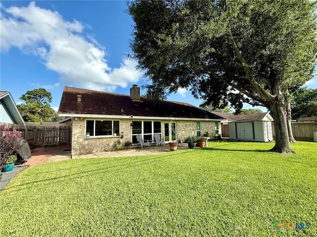 107 Savannah Dr, Victoria, TX 77904 - back of property with a shed, a patio, brick siding, a chimney, and a fenced backyard