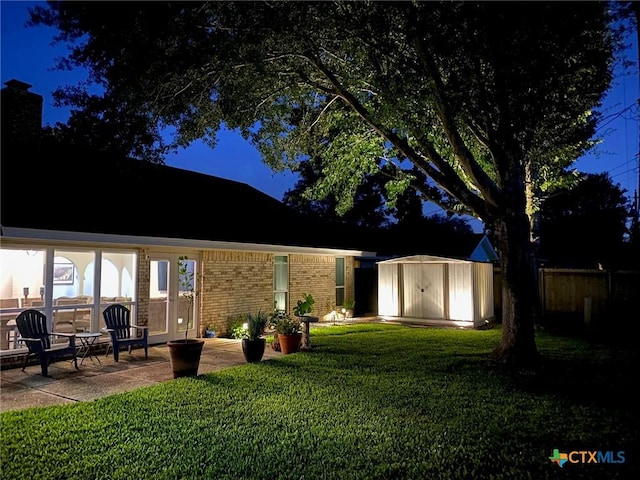 107 Savannah Dr, Victoria, TX 77904 - rear view of property with a storage shed, brick siding, a patio, and a chimney